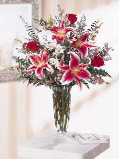 Valentine's Day vase containing flowers such as star gazer lilys, red roses and alstroemeria