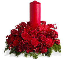 holiday floral arrangement with red candle. Filled with Christmas greens, red carnations, red roses  and ribbon